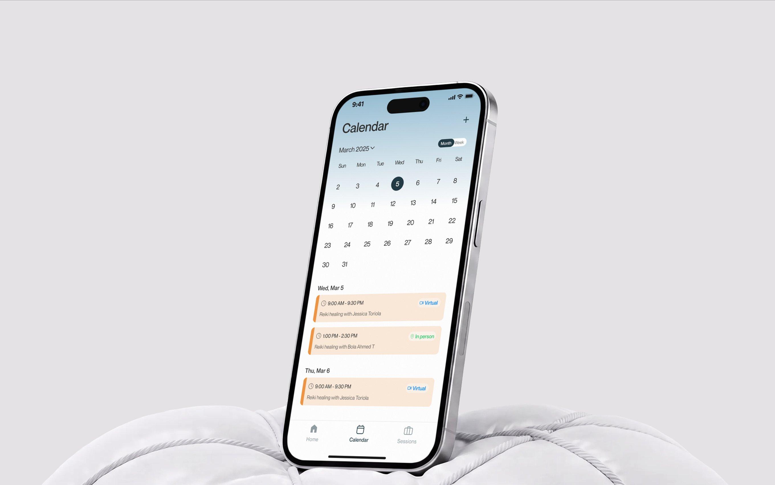 OOMA calendar on a phone resting on a white cushion