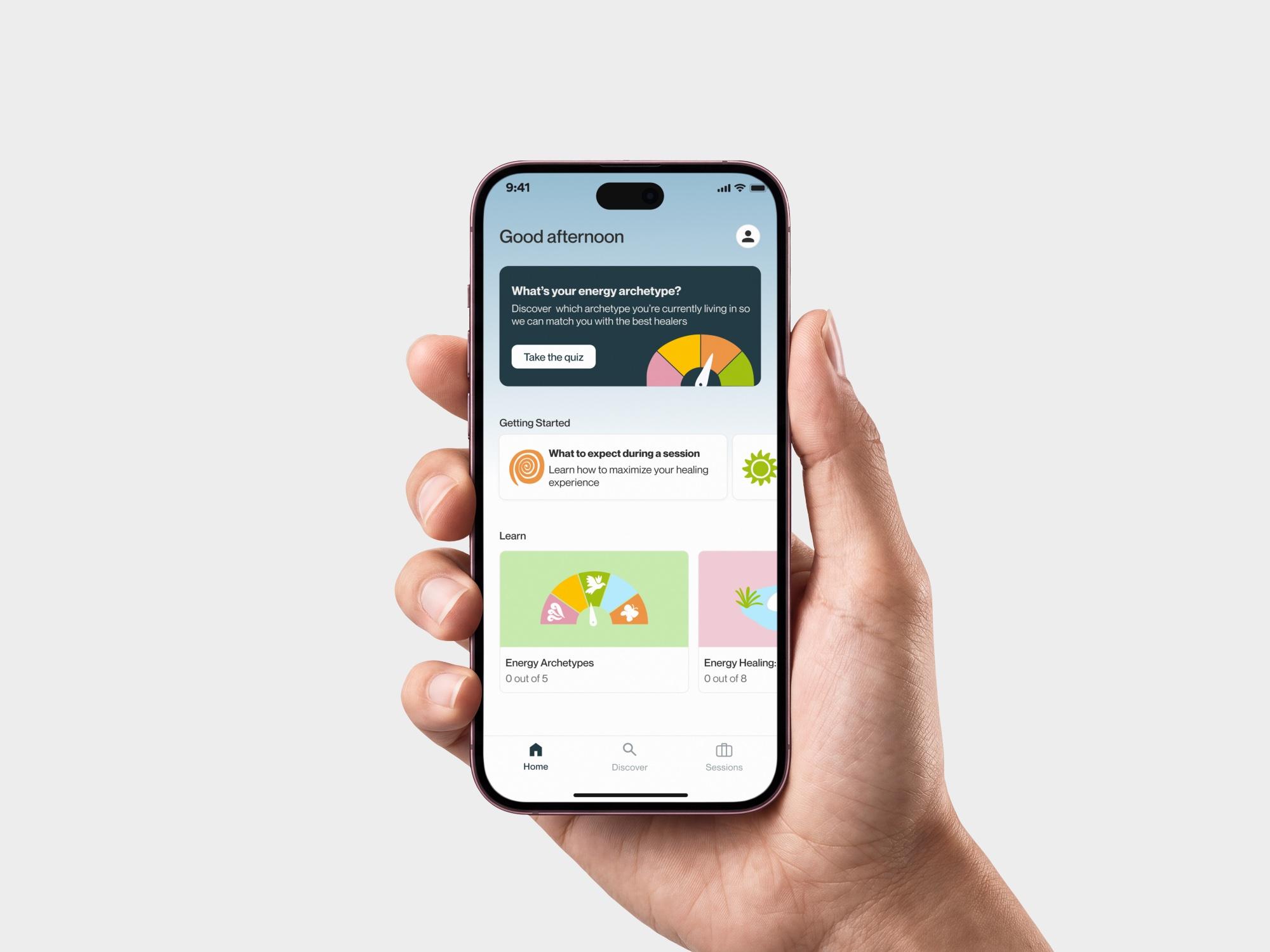 Hand holding a phone showing the OOMA home screen
