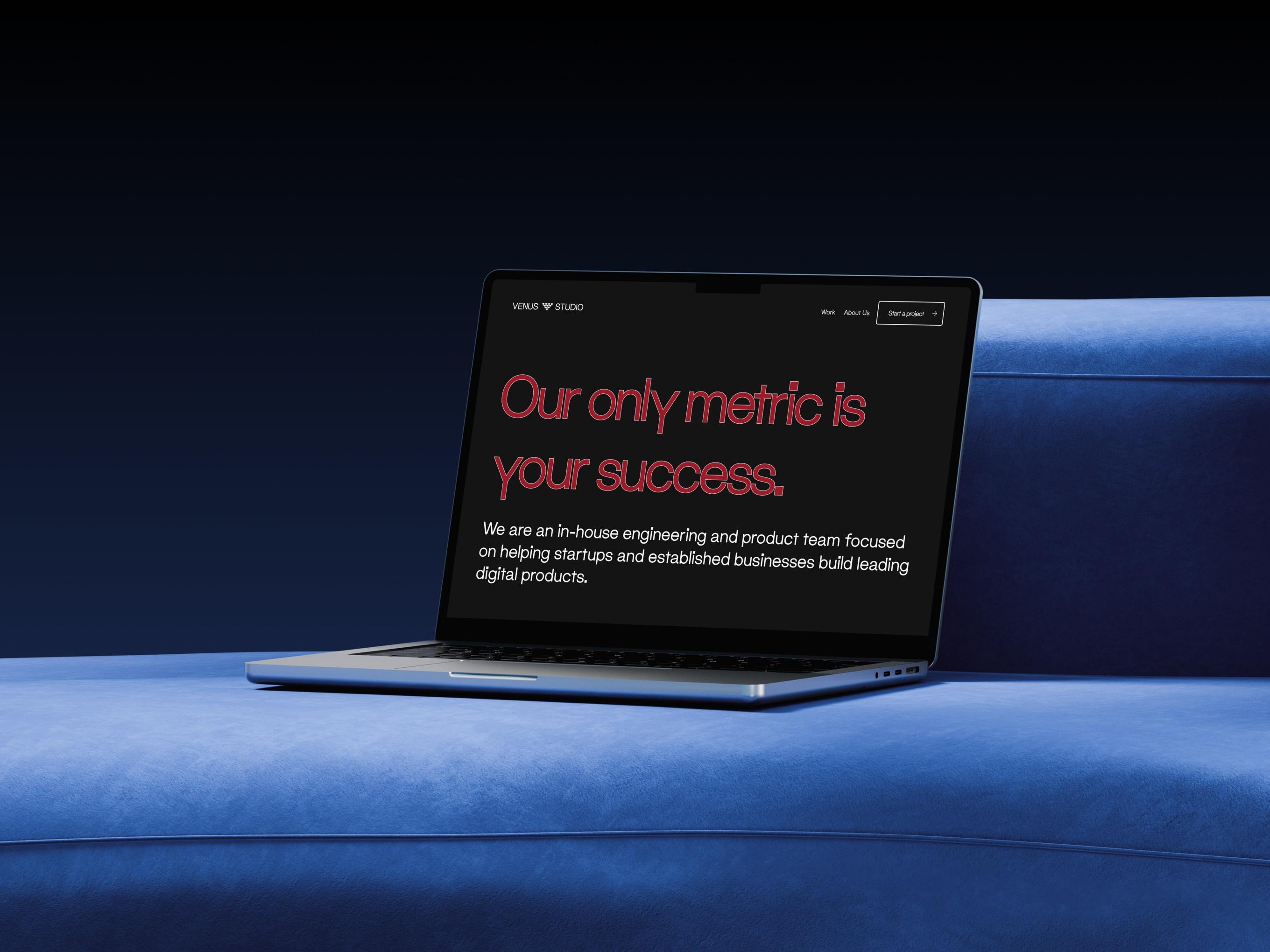 Laptop on a blue sofa showing the Venus Studio homepage